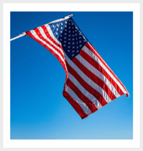 An American flag flying on top of a metal pole