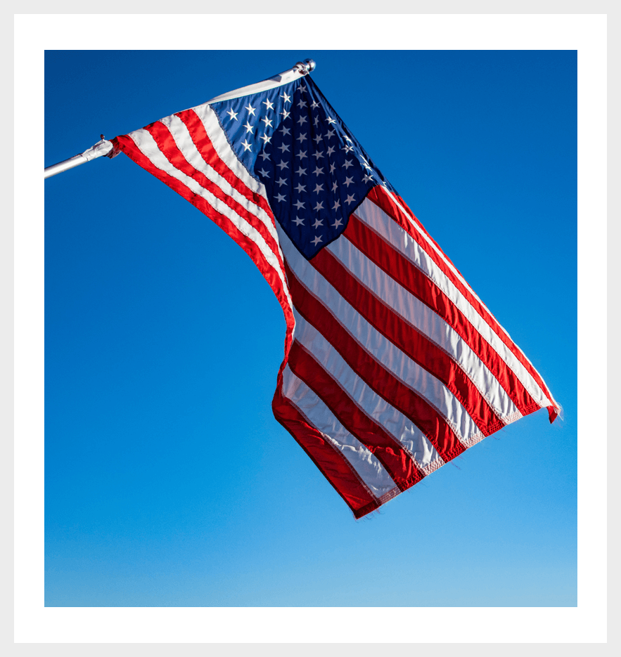 A flag flying in the sky on a sunny day.