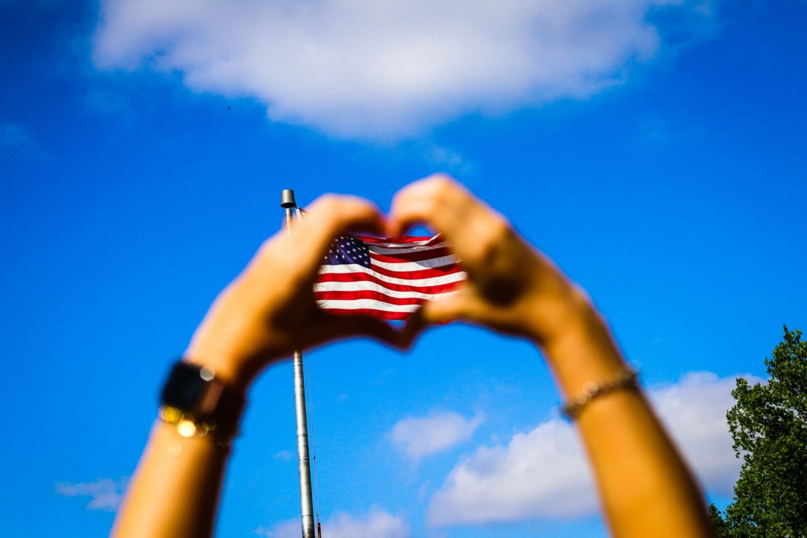 A person holding an american flag in the shape of a heart.