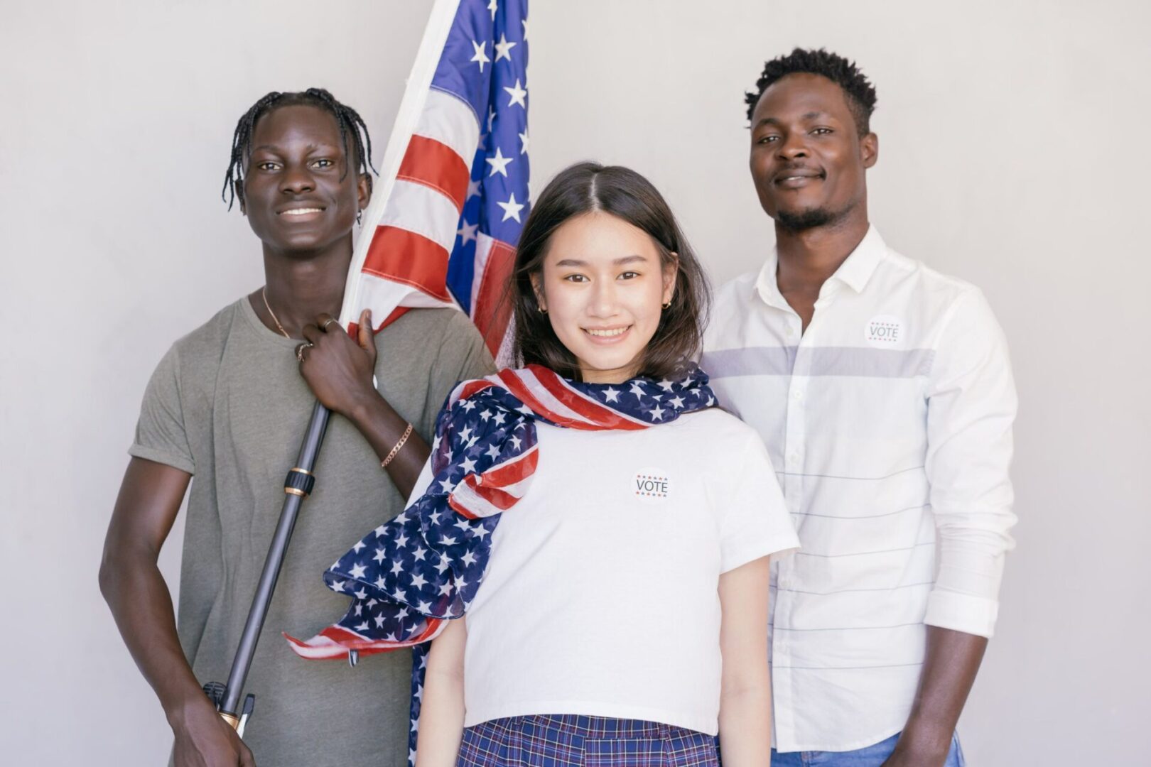 Three people standing next to each other holding a flag.