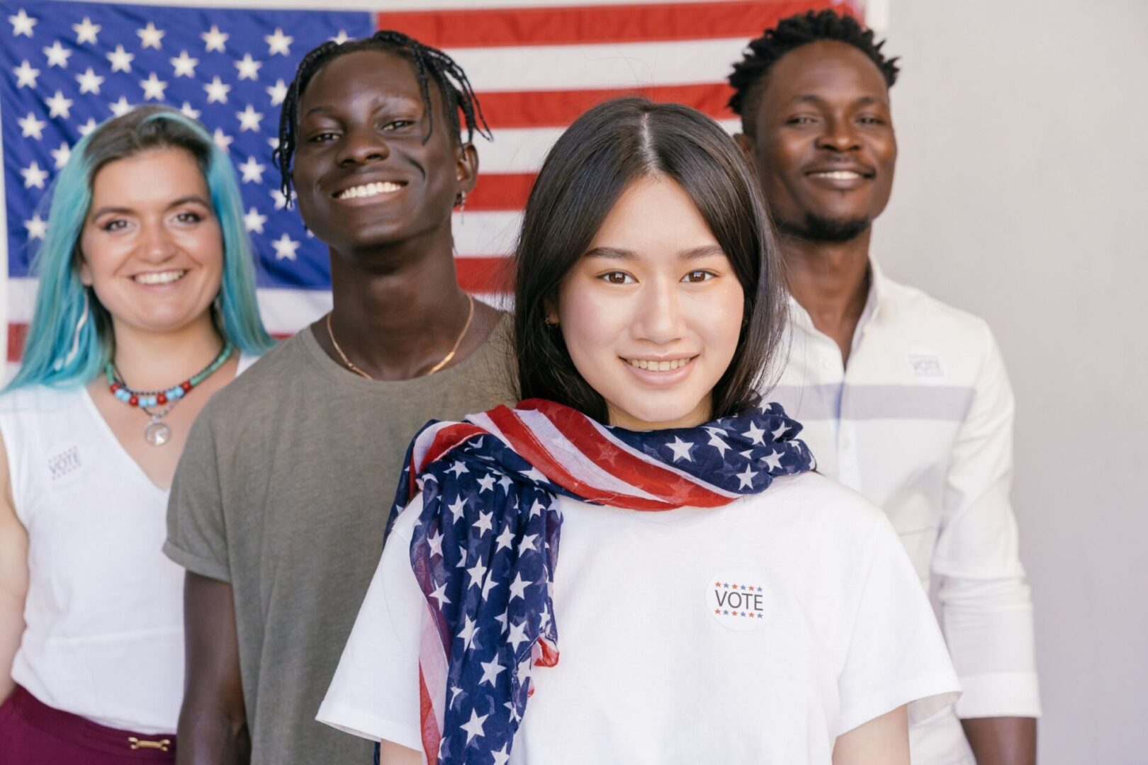 A group of people standing in front of an american flag.