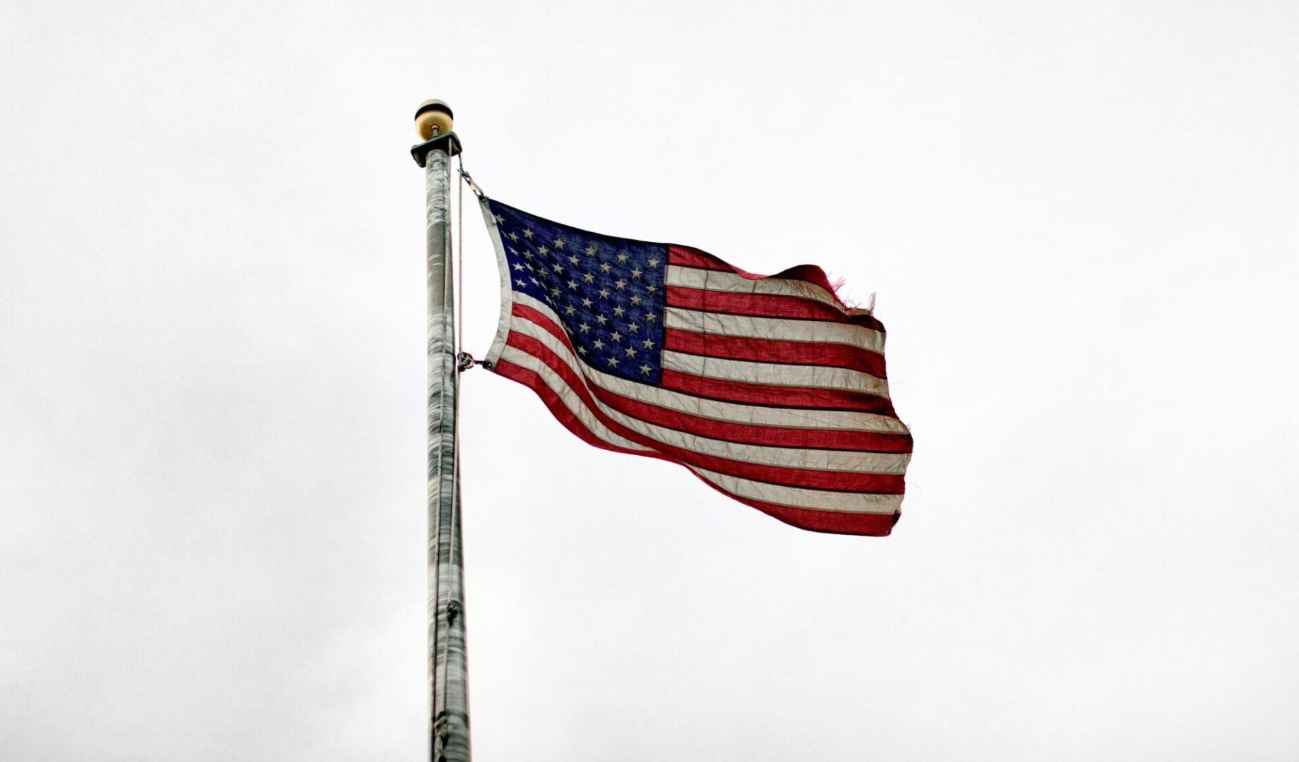 A flag flying on top of a metal pole.